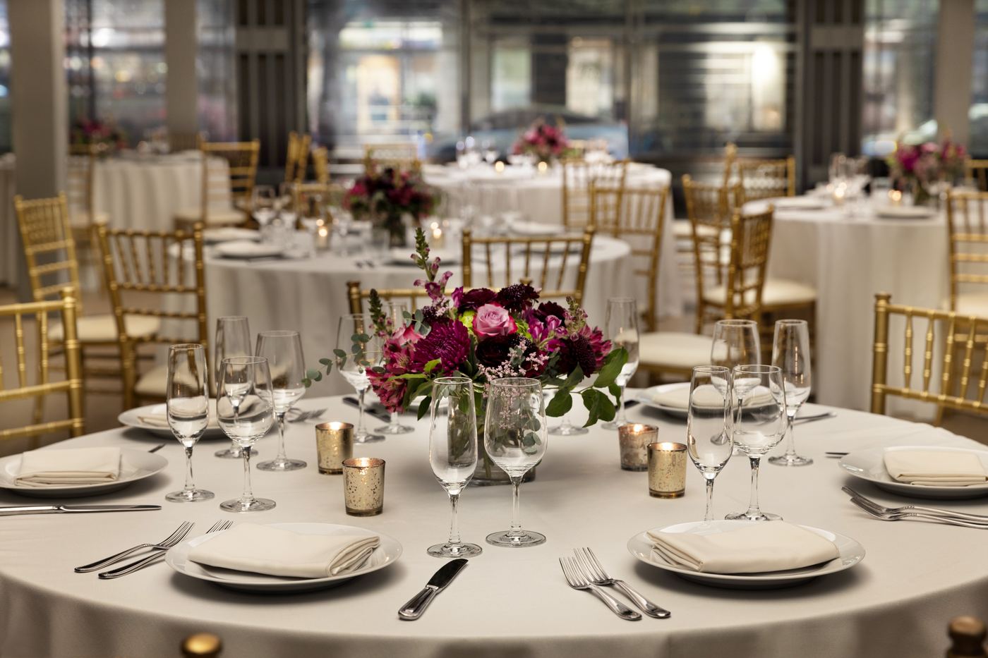 Elegantly set wedding reception table at Palladian Arthouse with gold chiavari chairs and floral centerpiece