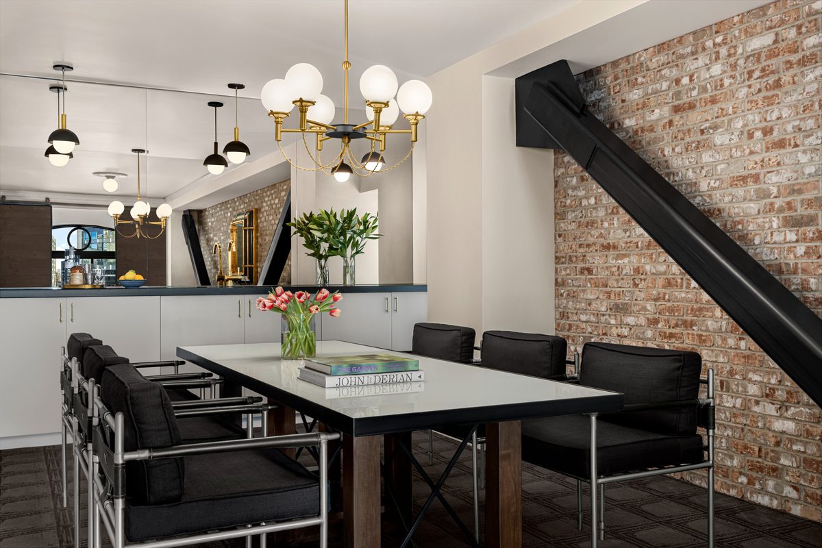 The Palladian Suite VIP room with exposed brick feature wall, brass chandelier and conference table